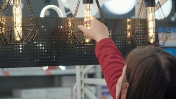 Mujer compra lámparas de estilo loft en una tienda — Vídeo de stock