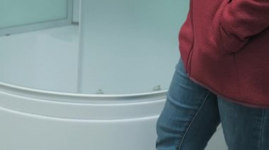 Dükkandaki kız banyo için duş tezgahı alıyor.