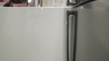 Maskeli kadın eski moda buzdolabı alıyor.