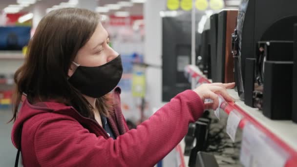 가전제품 가게에 있는 소녀는 새로운 오디오 시스템을 선택 한다 — 비디오