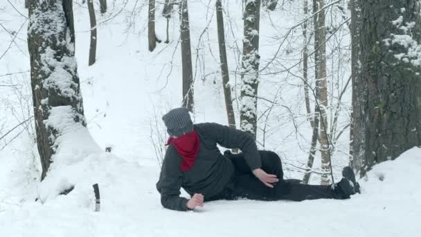 Человек альпинист был ранен в походе, он лежит и держит ногу — стоковое видео