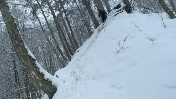 Альпинист спускается с горы и скатывается по снежному склону. — стоковое видео