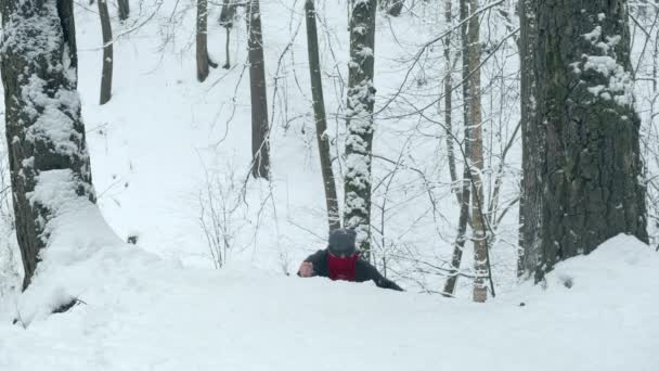 Mann mit rotem Kopftuch besteigt mit zwei Messern schneebedeckten Hügel — Stockvideo