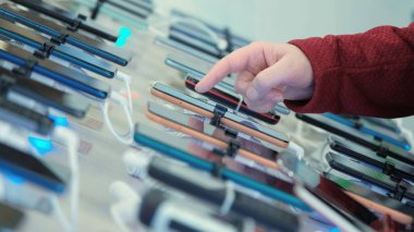 Alet dükkanında akıllı telefonu seçen bir kadın.