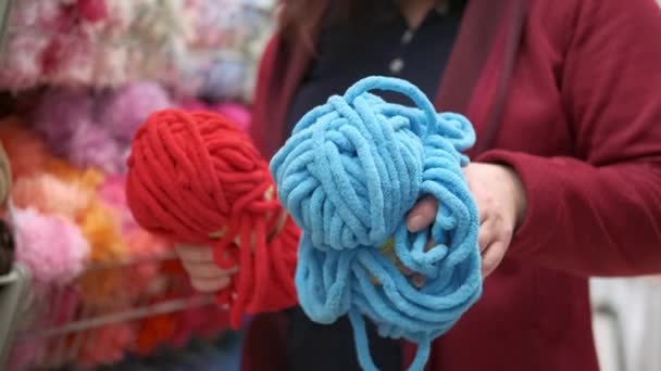 As mãos das mulheres escolhem o fio de chenille para tecelagem e tricô — Vídeo de Stock