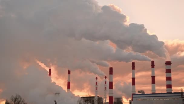 Tubos industriais enormes ao pôr do sol que emitem muita fumaça branca — Vídeo de Stock