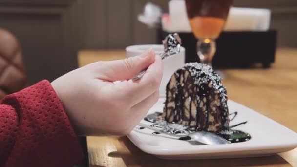 La mujer en la cafetería come pastel con tenedor. Café en las inmediaciones — Vídeo de stock