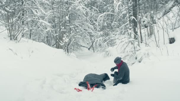 Kalter Winter. Mann schleift Verletzten auf Trage durch Schnee — Stockvideo