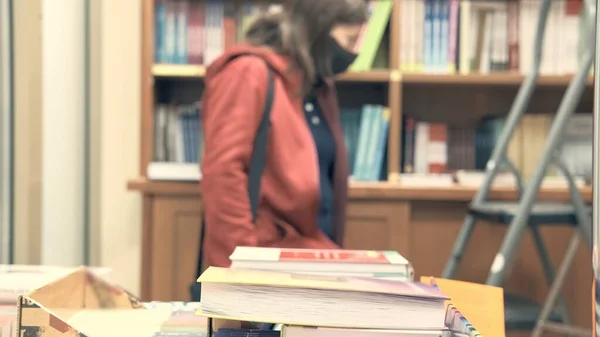 Woman in the library. She in blur, focus is in foreground — Stock Photo, Image