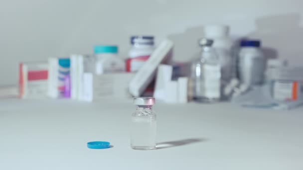 Η σύριγγα πέφτει και καταλήγει σε ένα βάζο με εμβόλιο κατά του ιού. — Αρχείο Βίντεο
