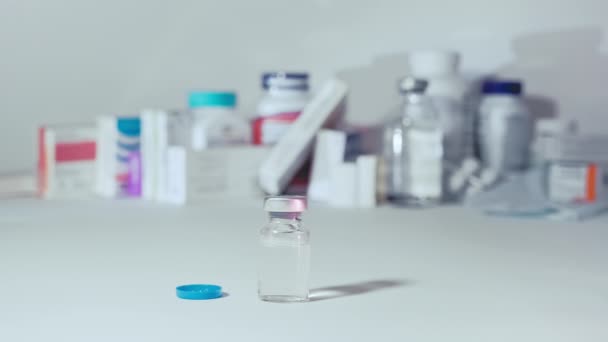 Injectiespuit naast de ampul van het vaccin — Stockvideo