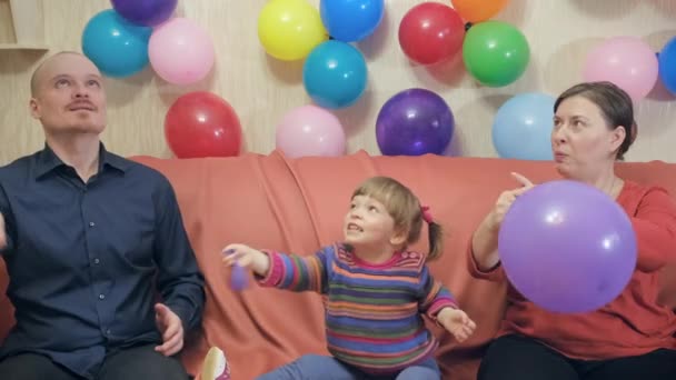 Mom, Dad and little daughter play with inflatable balloons — Stock Video