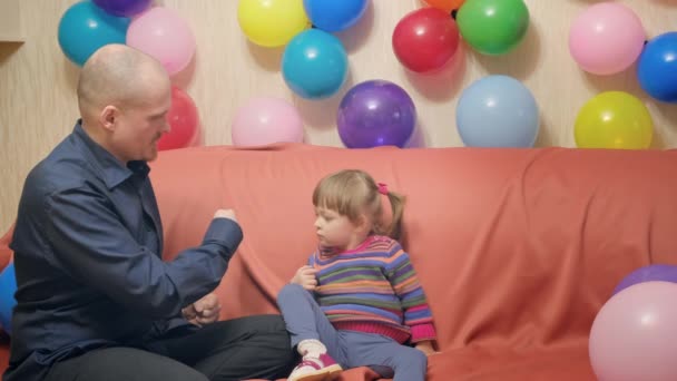 Батько показує маленькій доньці трюк зі зникненням пальця на руці — стокове відео