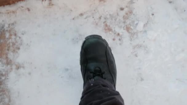 男の足は公園の木製の階段を覆った雪の上を歩く。雪がたくさん積もっている。 — ストック動画