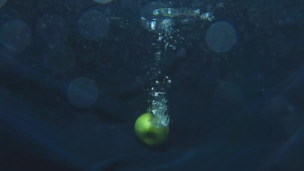 Reife grüne Apfelfrüchte fallen ins Wasser. Konzept der gesunden Ernährung und vegan — Stockvideo