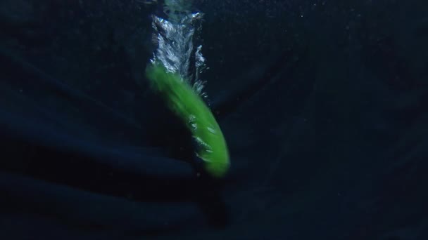 壮大なキュウリは急なスピンで水面を切断します。健康食品の概念 — ストック動画