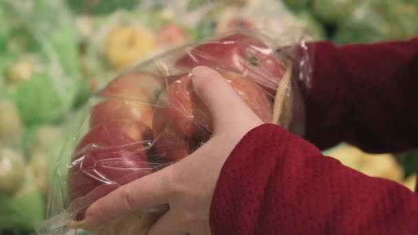 Meisjes in de winkel kopen een pakje met rode appels. close-up schot — Stockvideo