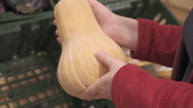 Dükkandaki kız taze, olgun bir su kabağı alır. Yakın çekim.