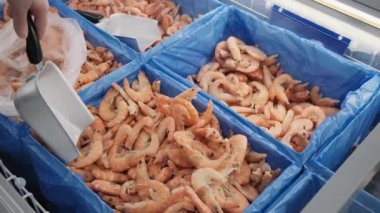 Dükkandaki kadın buzdolabından karides çıkarıyor. Tüketim suff proteini kavramı