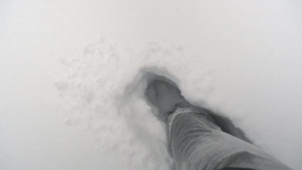 Os pés estão caminhando através de neve muito profunda. A cada passo, os sapatos afundam profundamente — Vídeo de Stock