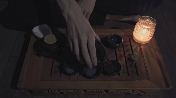 Tea master pours tea into small, clay cups. Concept Japanese tea ceremonies