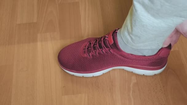 De man in de schoenenwinkel past rode, sportieve sneakers. Concept van winkelen, sport — Stockvideo
