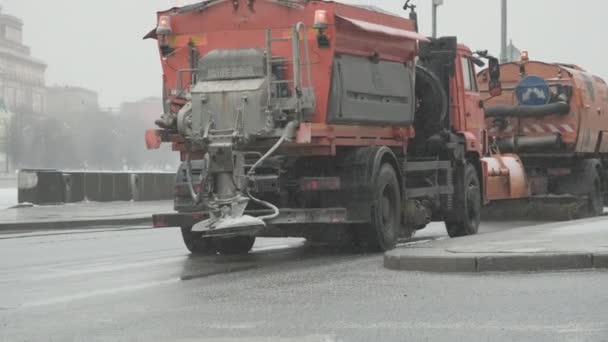 Winter, sněží. Na silnici, dvě oranžová auta jedou vyčistit silnice — Stock video
