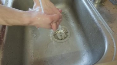 Adam ellerini yıkıyor. Havluyla siler ve nemlendiriciyle siler.