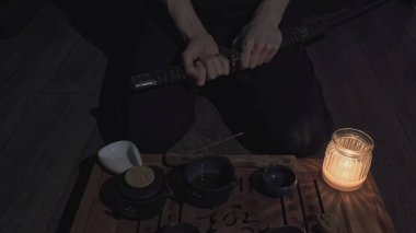 Çay tahtası ve bardaklar. İnsan kılıcını kınından çıkarır samuray kılıcını
