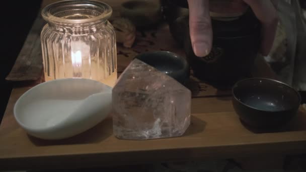 Sur le plateau de thé, il y a un cristal magique et une bougie. La main verse la boisson dans des tasses — Video