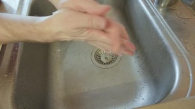 Adam dikkatli, uzun zamandır ellerini metal lavaboda yıkıyor. Hijyen kavramı