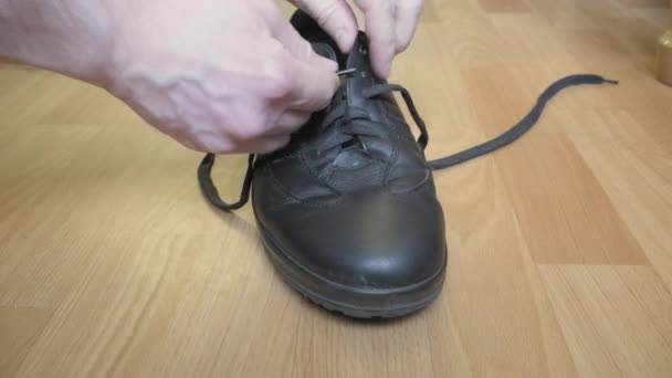 De man doet schoenveters in zijn schoenen voor het najaarsseizoen. close-up schot — Stockvideo