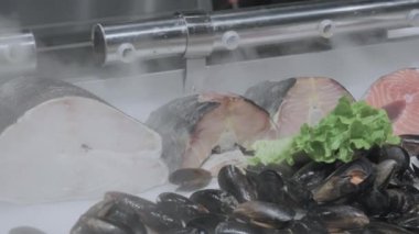 Balık ve istiridye buzun üzerinde duruyor. Üzerlerinde soğuk buhar servis edilir.
