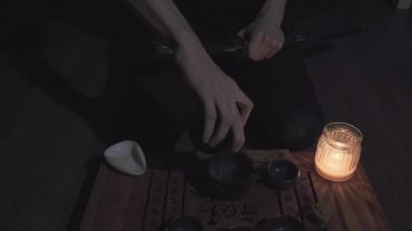 Adam Japon kılıcını kınına sokuyor. Sonra kendine bir fincan çay ve içki doldurur.