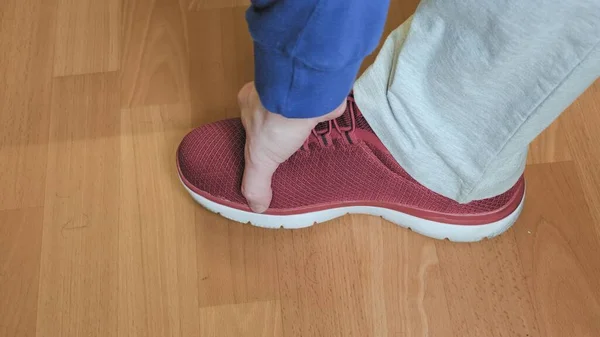 Ayakkabıcıdaki adam kırmızı spor ayakkabıları deniyor. Alışveriş anlayışı, spor