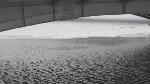 Rzeka pod żelaznym mostem pokryta jest skorupą lodu. Śnieg pada — Wideo stockowe