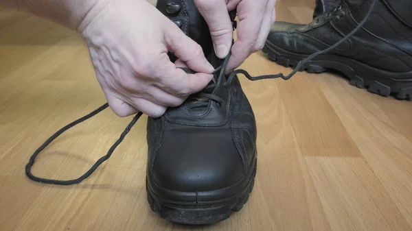 Man puts shoelaces in his shoes for the winter season. Close up shot — Stock Photo, Image