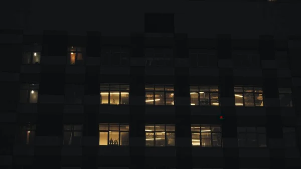 Noite de edifício moderno. Na casa grande, as janelas estão acesas — Fotografia de Stock