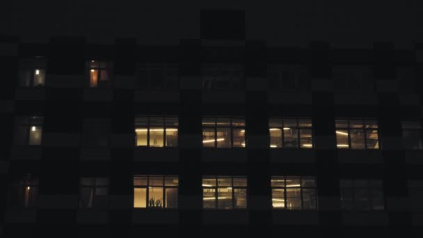 Noite de edifício moderno. Na casa grande, as janelas estão acesas — Vídeo de Stock