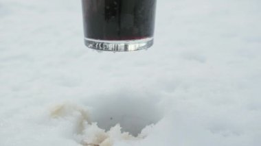 Erkek eli karda serinlemek için koyu, sert bir bira koyar.