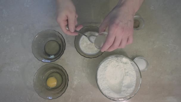 Чоловік додає сухі дріжджі до молока, щоб зробити кислоту. Поруч з ним борошно, яйце, сіль — стокове відео
