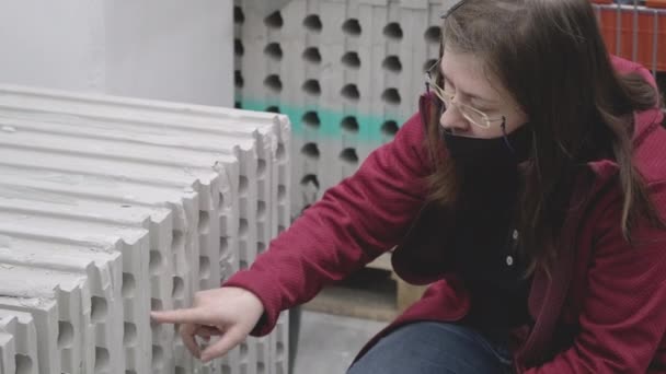 Mujer con máscara contra virus compra hormigón de espuma en la tienda de materiales de construcción — Vídeos de Stock