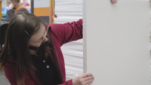 Žena v masce proti viru koupit polystyren pro opravy v obchodě stavebních materiálů — Stock video