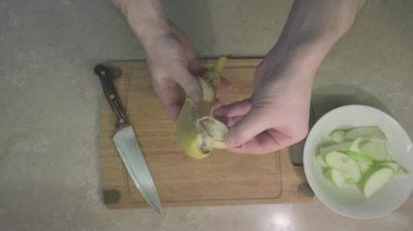 Adam tatlı meyve salatası yapmak için muz kabuğu soyar. Kapat.