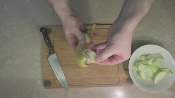 Människan skalar ett bananskal för att göra en söt fruktsallad. Närbild — Stockvideo