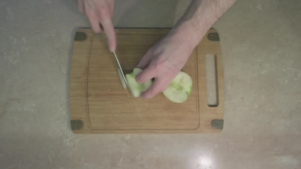 Seorang pria mengiris irisan apel untuk salad buah manis. Konsep makanan sehat. — Stok Video