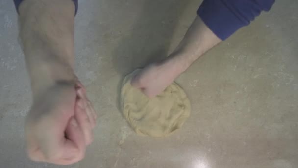 L'homme frappe la pâte avec ses poings qui la pétrissent. Concept de la cuisine maison comme passe-temps — Video