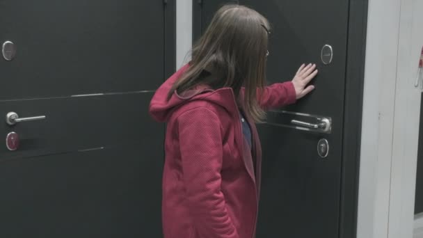 Vrouw in een bouwmateriaalwinkel kiest voor een zwarte, ijzeren deur om te kopen — Stockvideo