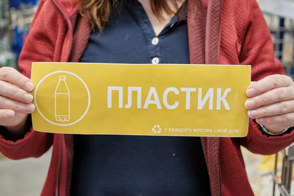Девушка держит знак на русском языке - пластик, каждый мусор имеет свой дом — стоковое фото
