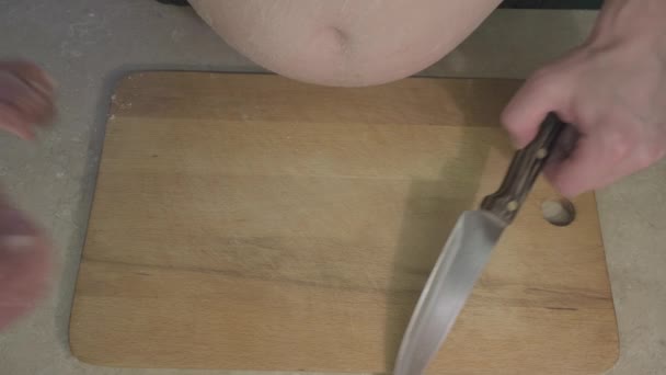 Dicker Kerl mit dem Wort Koch auf dem Bauch schneidet lässig rotes Schweinefleisch mit Messer — Stockvideo